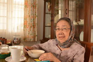 senior woman eating soup and dinner table