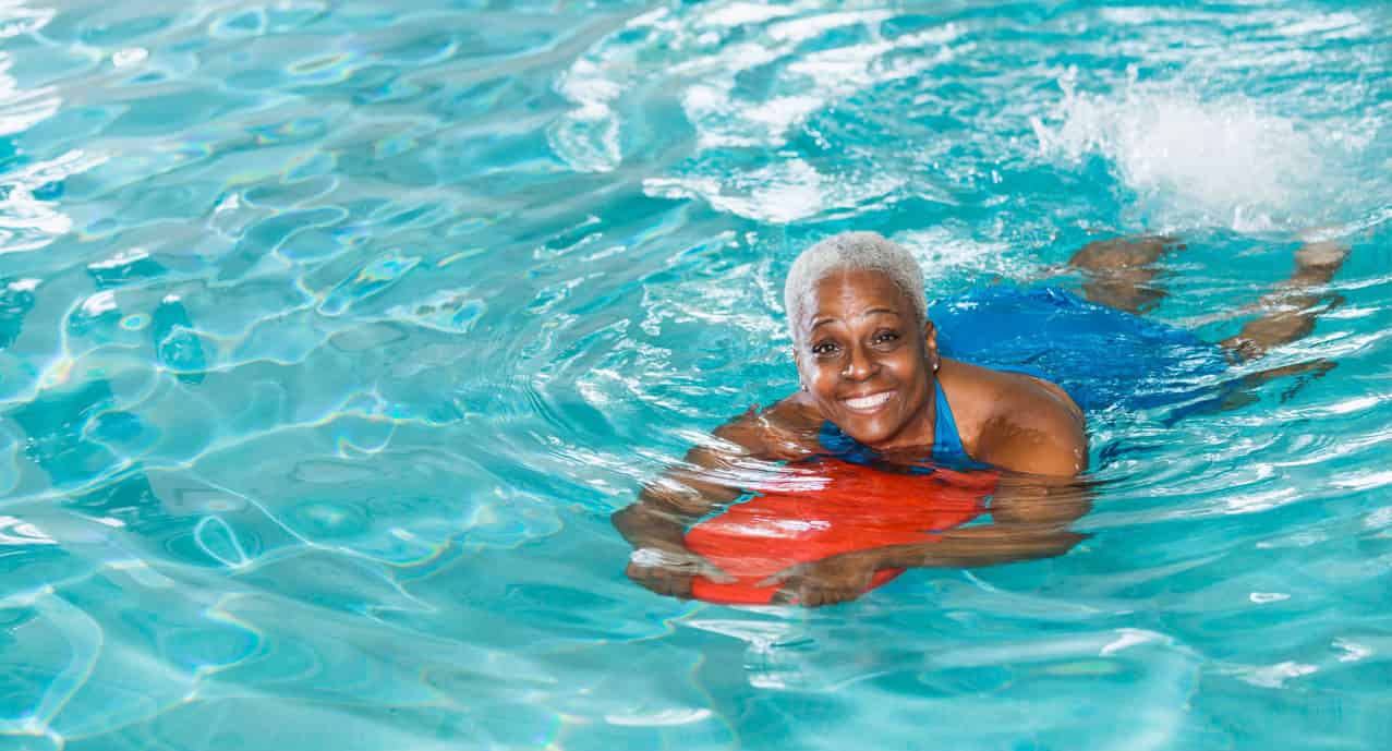 older woman in pool with ball