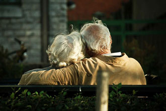 two seniors on a park bench in love